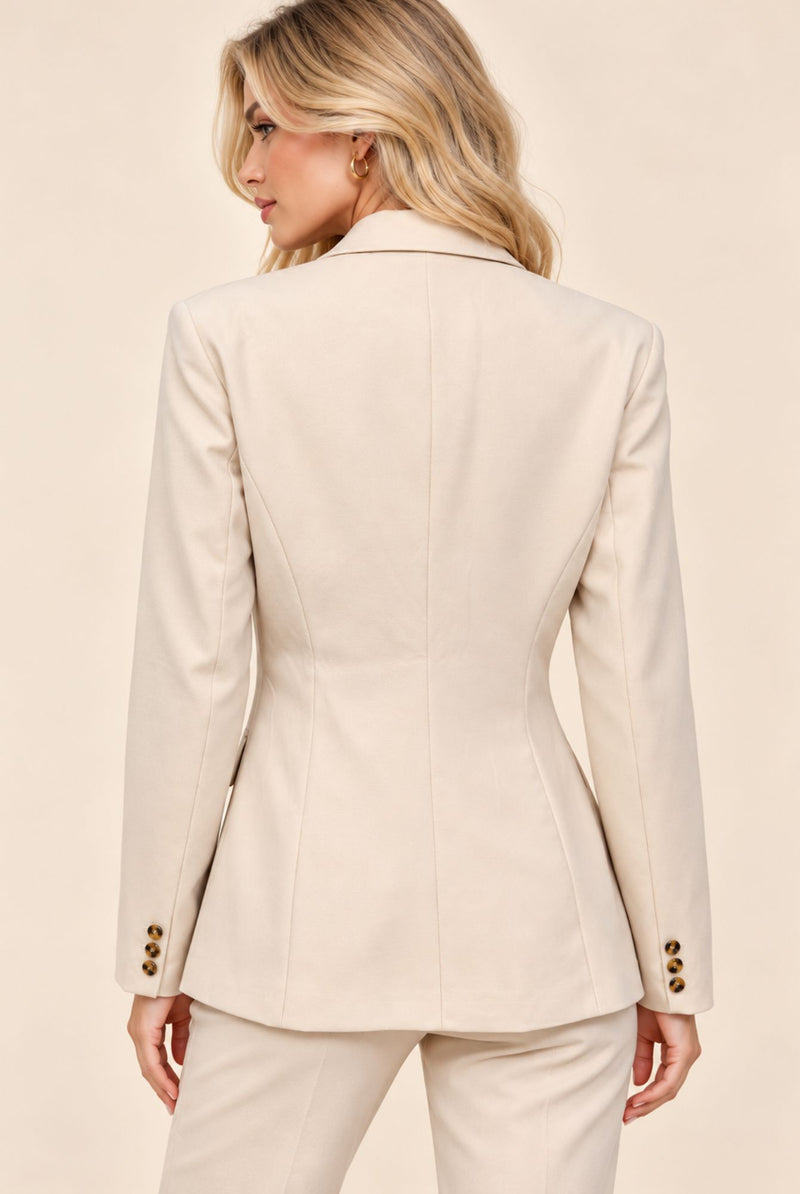 Back view of cream tailored blazer with shaped seams and button cuff detailing